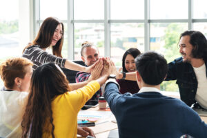 How to be a great team leader: Group Of Young Multiethnic Diverse People Gesture Hand High Five